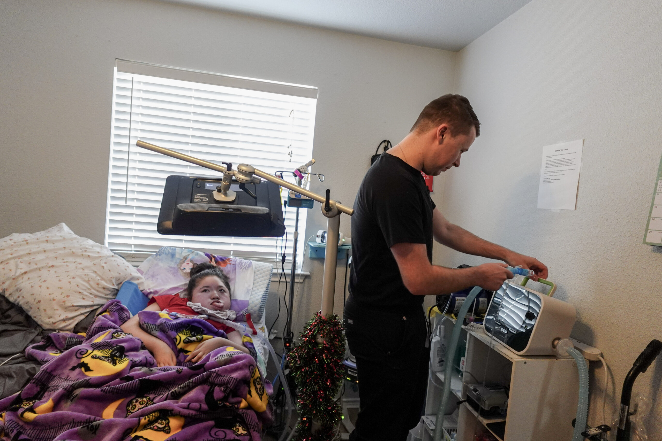 Nurse adjusting medical equipment with an adult patient